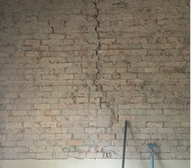 Extensive cracking in a brick wall with render removed